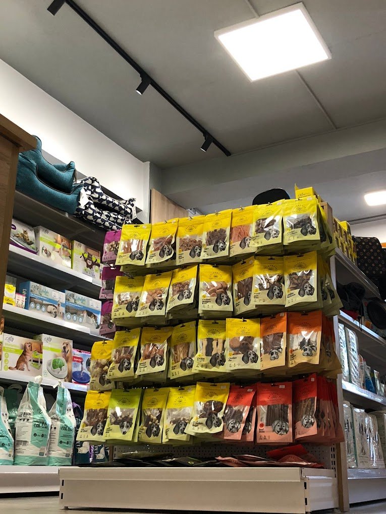 Pet food, treats, bed and other supplies on sheet at pet store